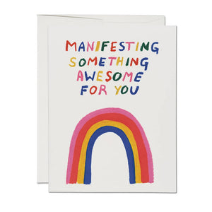 White background with image of rainbow and rainbow text says, "Manifesting something awesome for you". White envelope included.