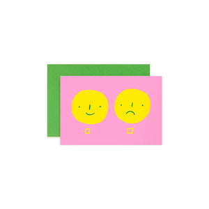 Greeting card with pink background and two yellow smiley faces, one smiling and one sad with yellow checkboxes. Green envelope included. 