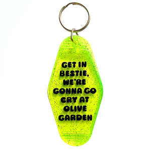 Image of motel style keychain with neon green background with black text says, "Get in bestie, we're gonna go cry at olive garden". 