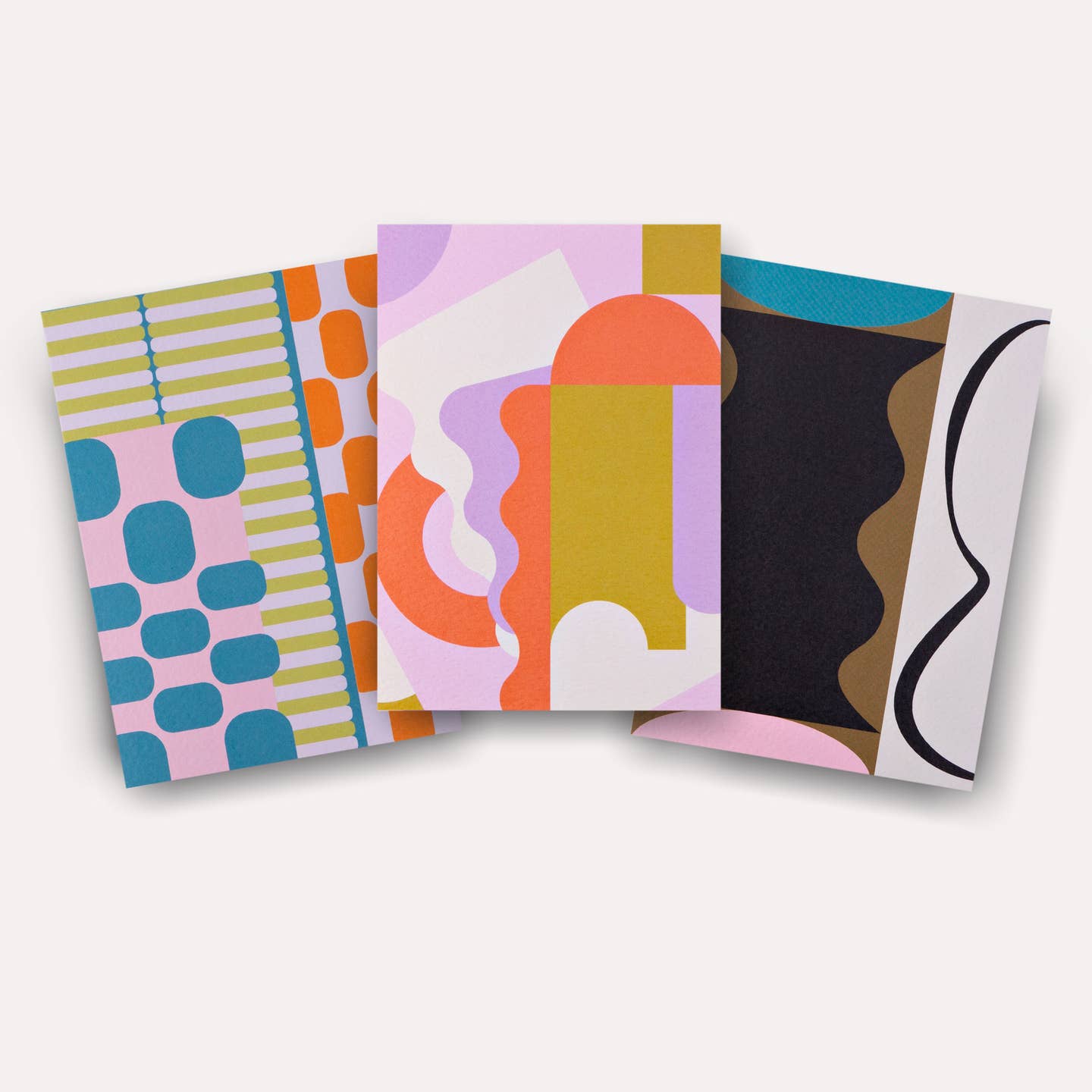 Note card set with graphic designs in olive, teal, orange, white and black. 