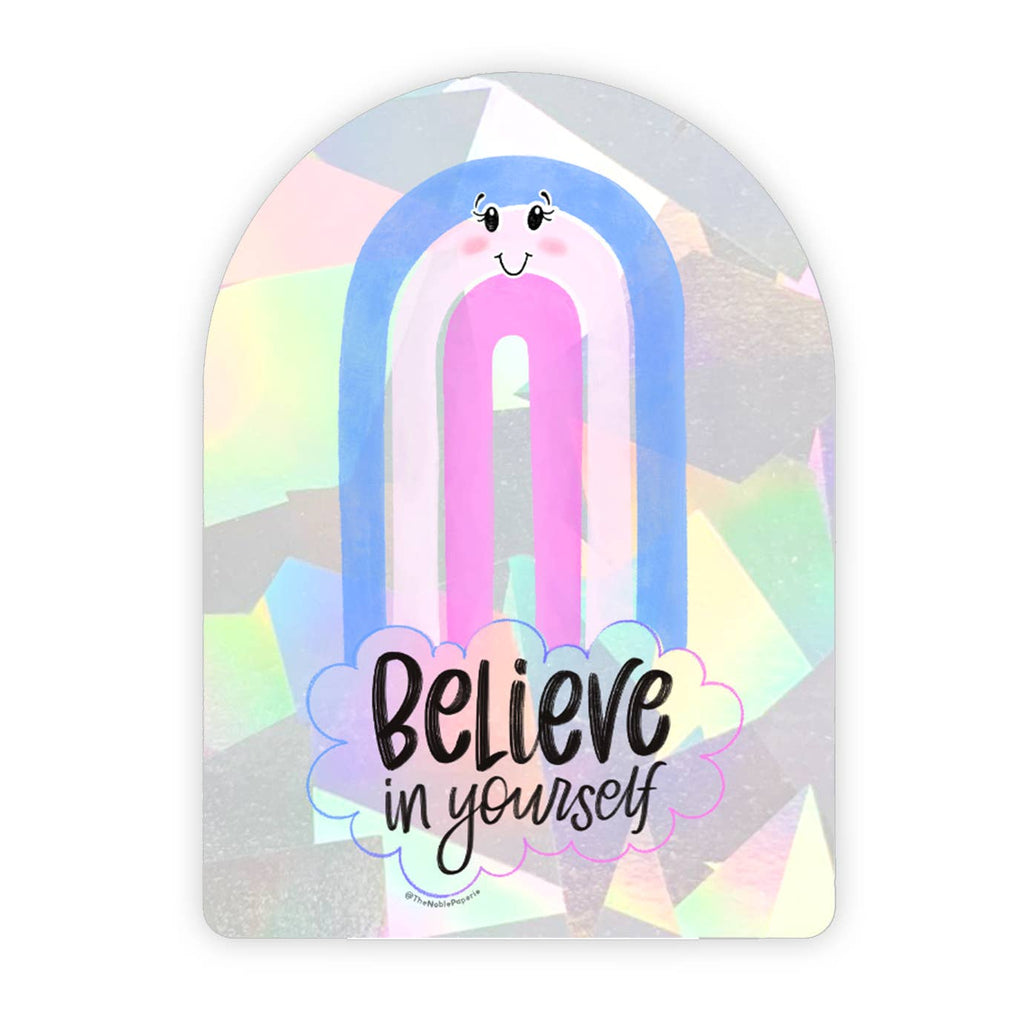 Holographic background with blue, white and pink rainbow with a face and a cloud below with black text says, “Believe in yourself”. 