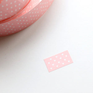 Label sticker with pink background and white dots.