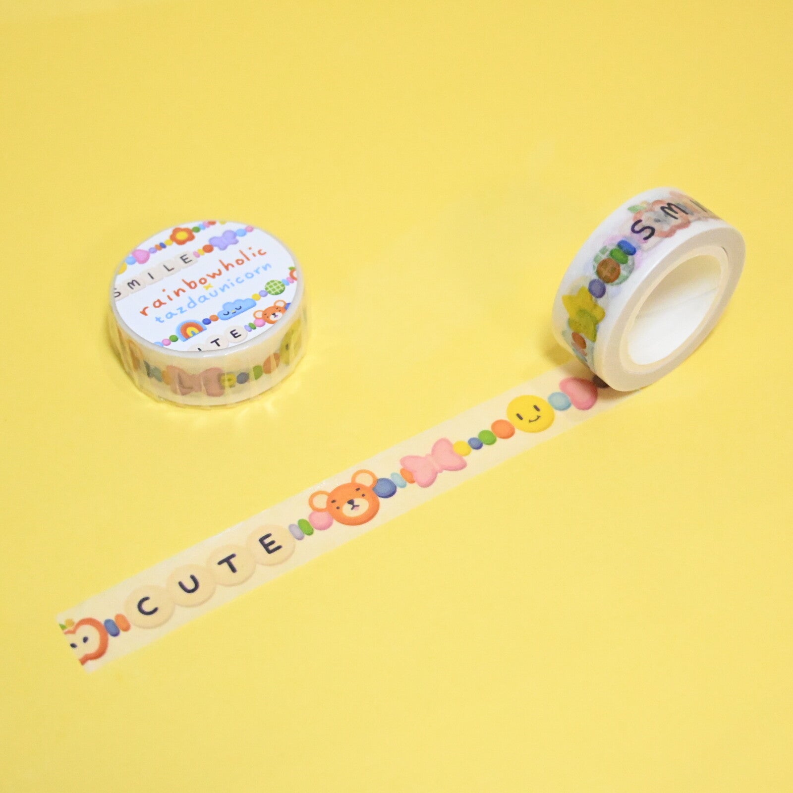 Roll of decorative tpe with clear background and images of beads and letters in different colors.