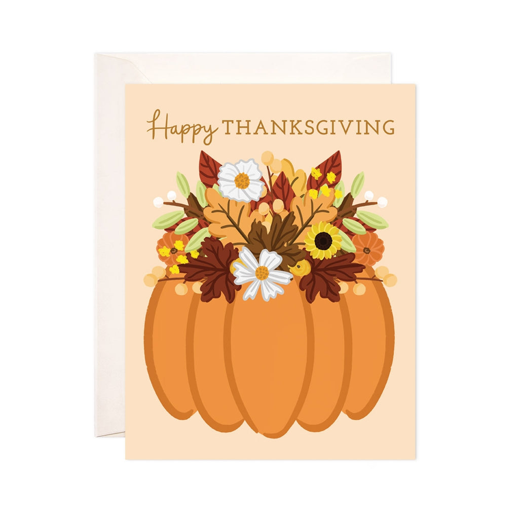 Light orange card with dark orange text saying, "Happy Thanksgiving". Image of a pumpkin with fall flowers coming out the top. An ivory envelope is included.