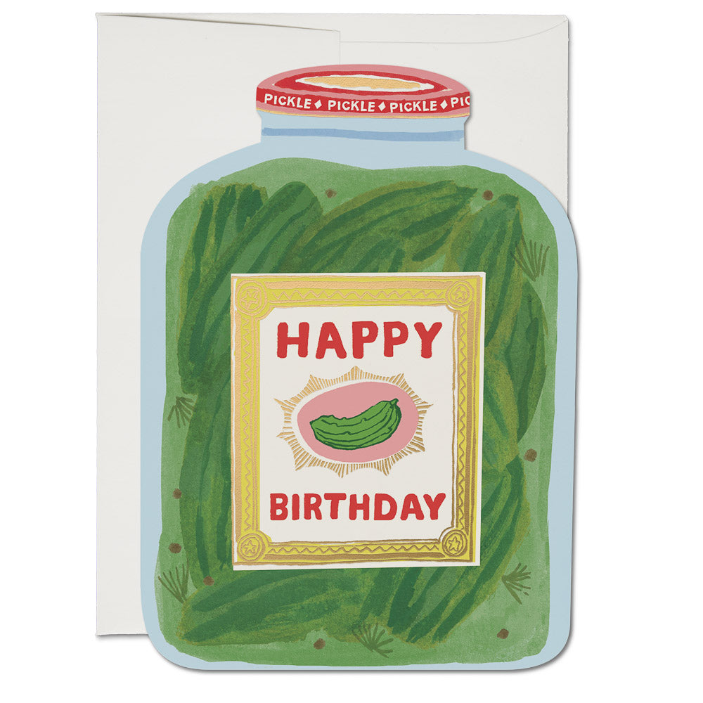 Blue card in the shape of a pickle jar with image of a jar of pickles with a red cap and gold label with red text saying, “Happy Birthday”. A white envelope is included.