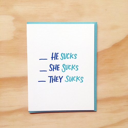 White card with blue text saying, “He Sucks She Sucks They Sucks”. A blue envelope is included.