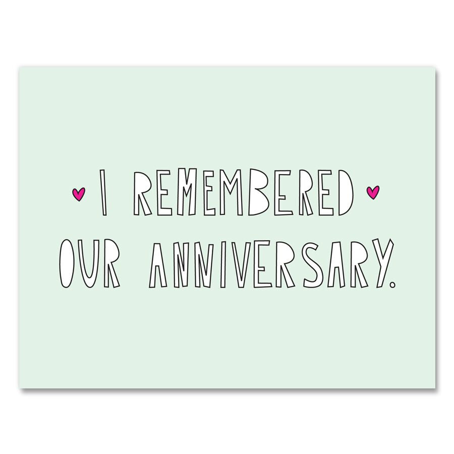 Light green card with white block text saying, "I Remembered Our Anniversary". Images of two small pink hearts. An envelope is included.