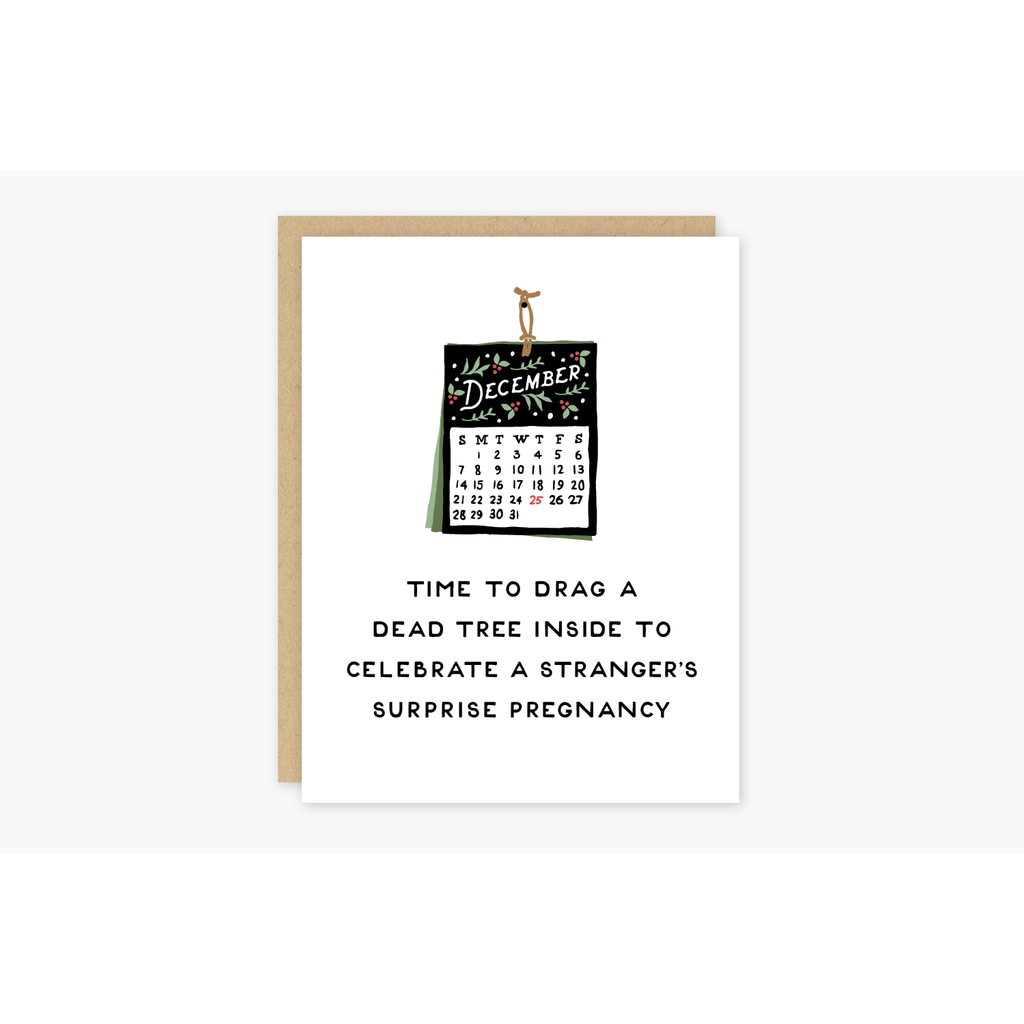 White card with black text saying, “Time to Drag A Dead Tree Inside To Celebrate A Stranger’s Surprise Pregnancy”. Images of a December wall calendar. A brown envelope is included.