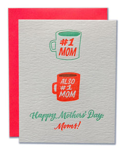 Gray card with teal and orange script text saying,"Happy Mother's Day, Dads!" Images of two teal and orange coffee cups, one saying "#1 Mom", the other saying "Also #1 Mom". A red envelope is included.