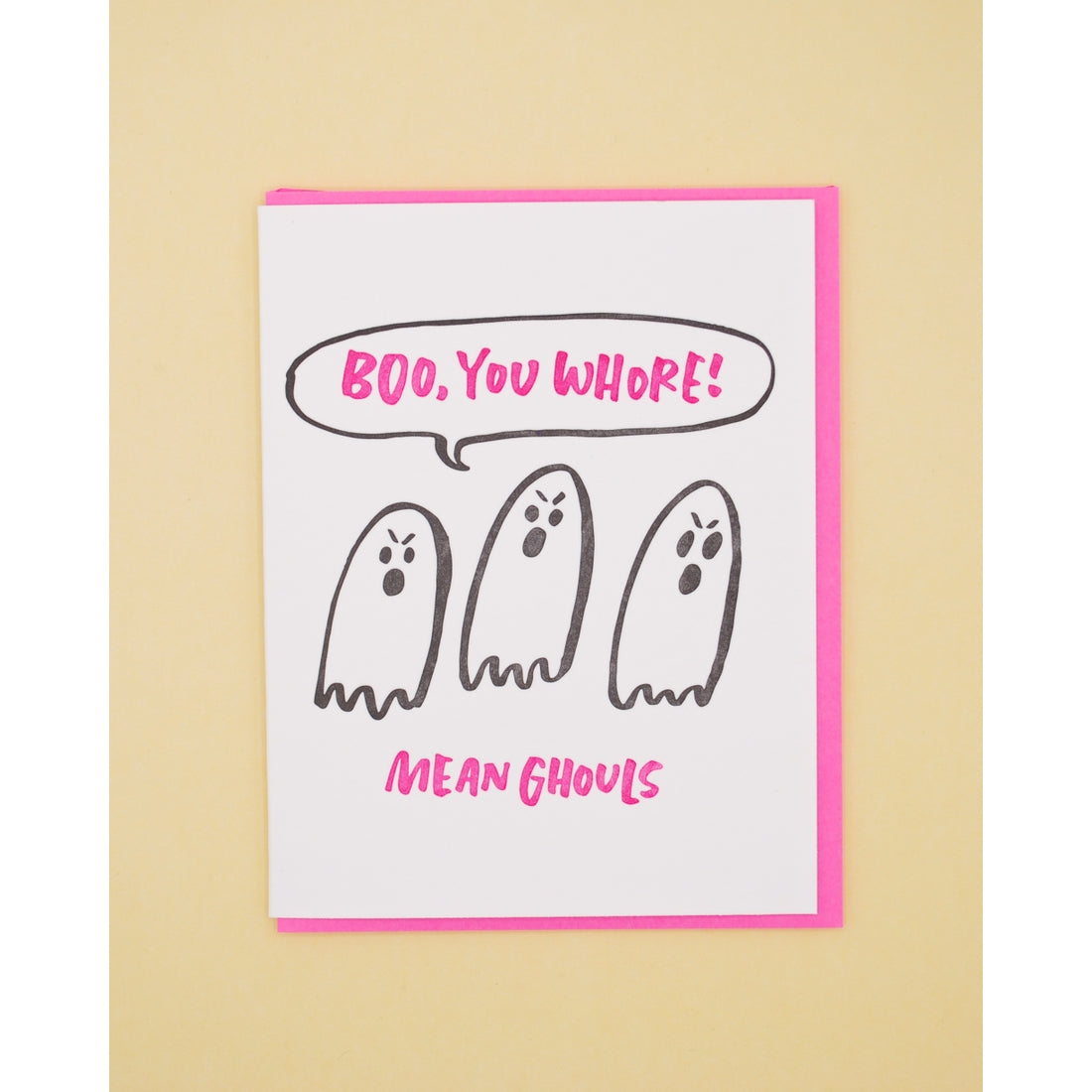 White card with dark pink text saying, "Boo, You Whore! Mean Ghouls". Image of three mean ghosts. A neon pink envelope is included.