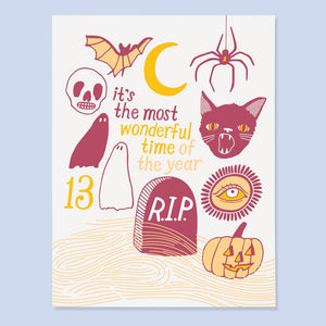 White card with red and yellow text saying, “It’s the Most Wonderful Time of the Year”. Images of Halloween symbols including a black cat, ghost, bat and spider. An envelope is included.