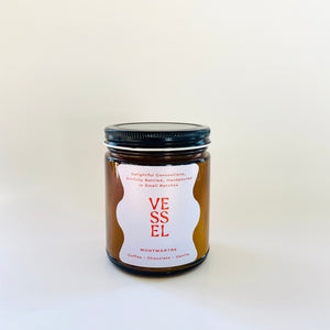 Image of brown glass jar with black lid and ivory label with red text says, “Vessel” and “Monmarte”. 