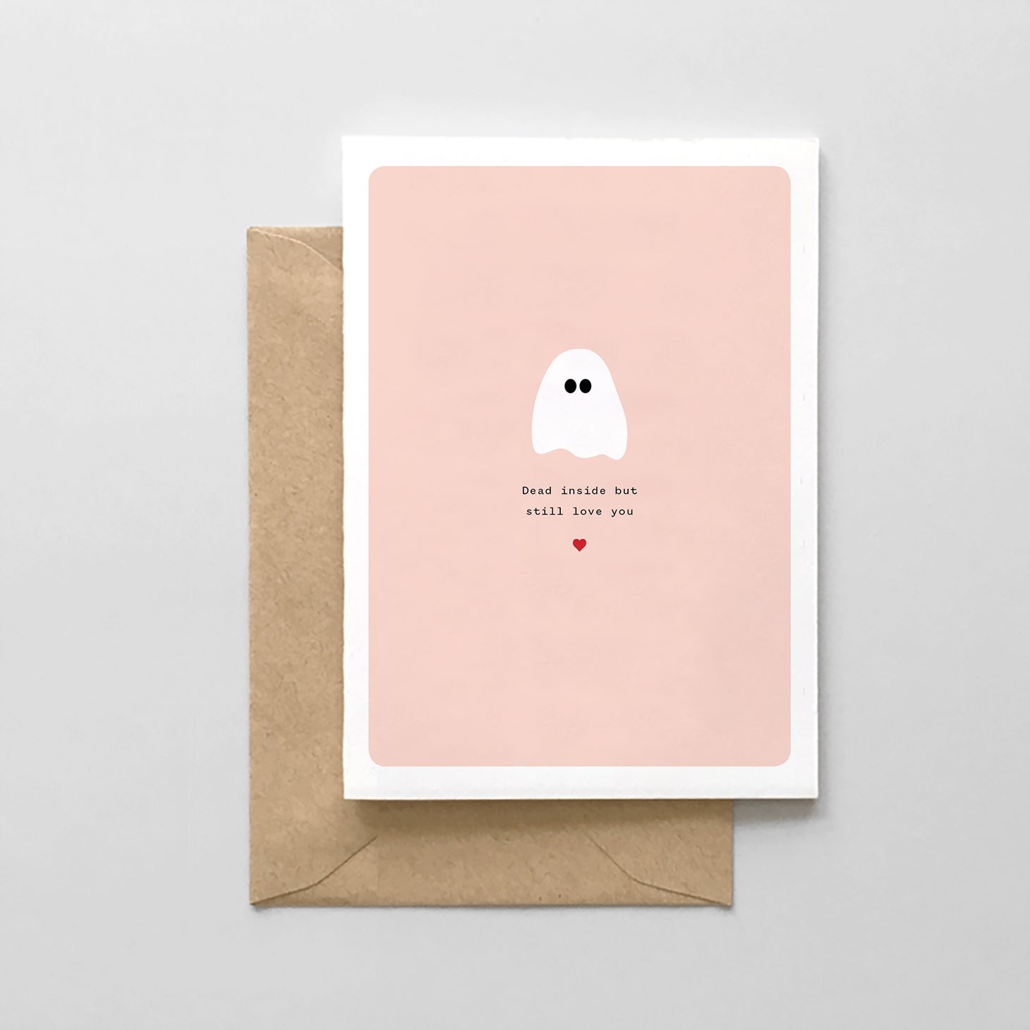 White card with peach background and black text saying, "Dead Inside But Still Love You". Images of a white ghost and red heart. A brown envelope is included.