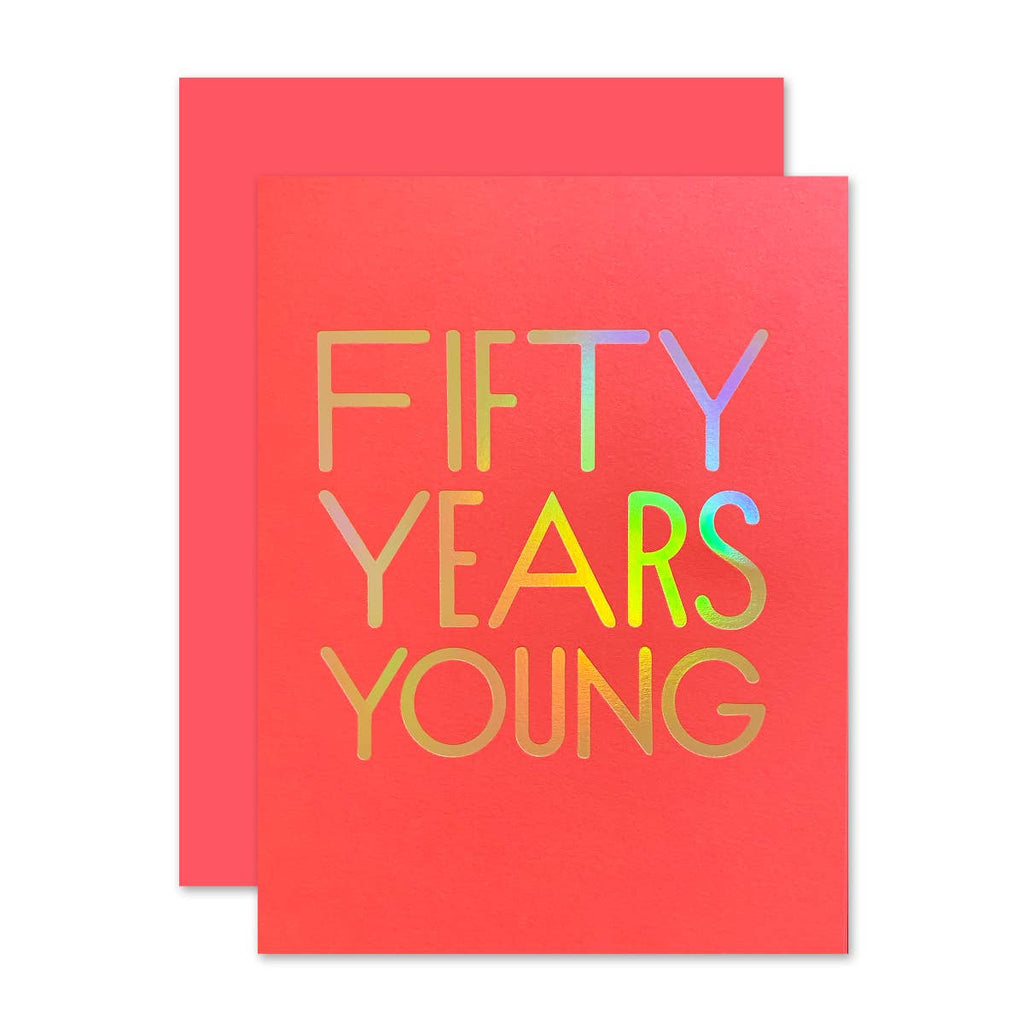 Orange card with gold foil rainbow text saying, “Fifty Years Young”. An orange envelope is included.