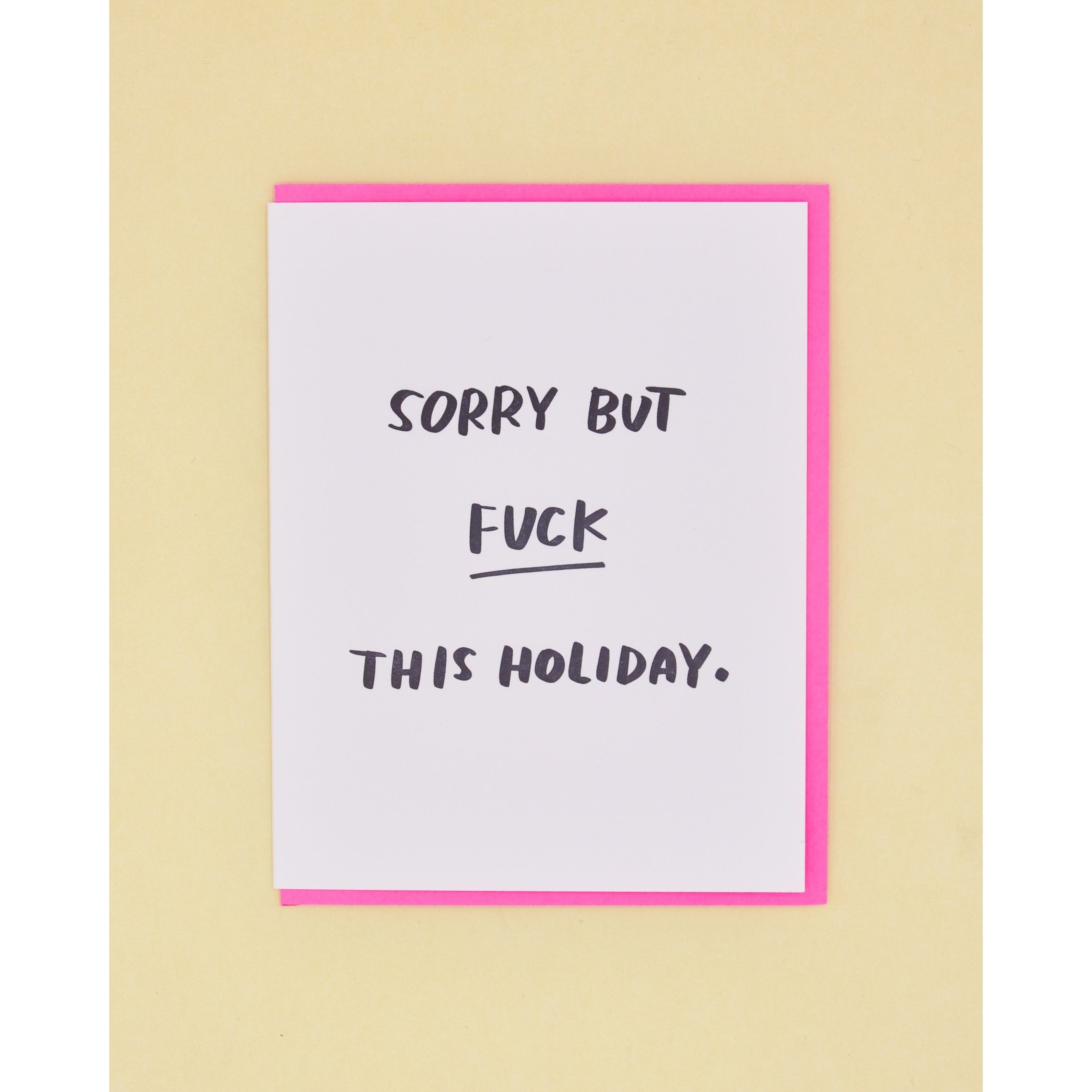 White card with black text saying, "Sorry But Fuck This Holiday". A neon pink envelope is included.