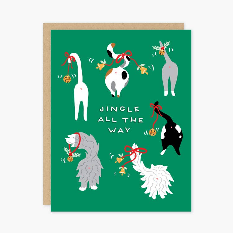 Green card with white text saying, “Jingle All The Way”. Images of cat behinds and tails with jingle bells attached to them. A brown envelope is included.