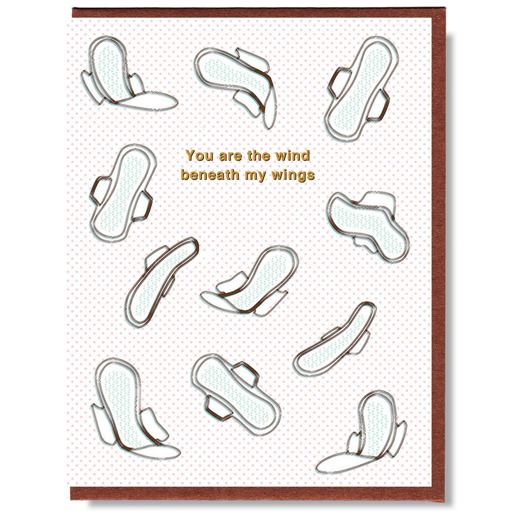 White card with pink dots and brown text saying, “You Are the Wind Beneath My Wings”. Images of white winged maxi pads floating across card. A brown envelope is included.