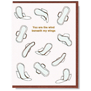 White card with pink dots and brown text saying, “You Are the Wind Beneath My Wings”. Images of white winged maxi pads floating across card. A brown envelope is included.
