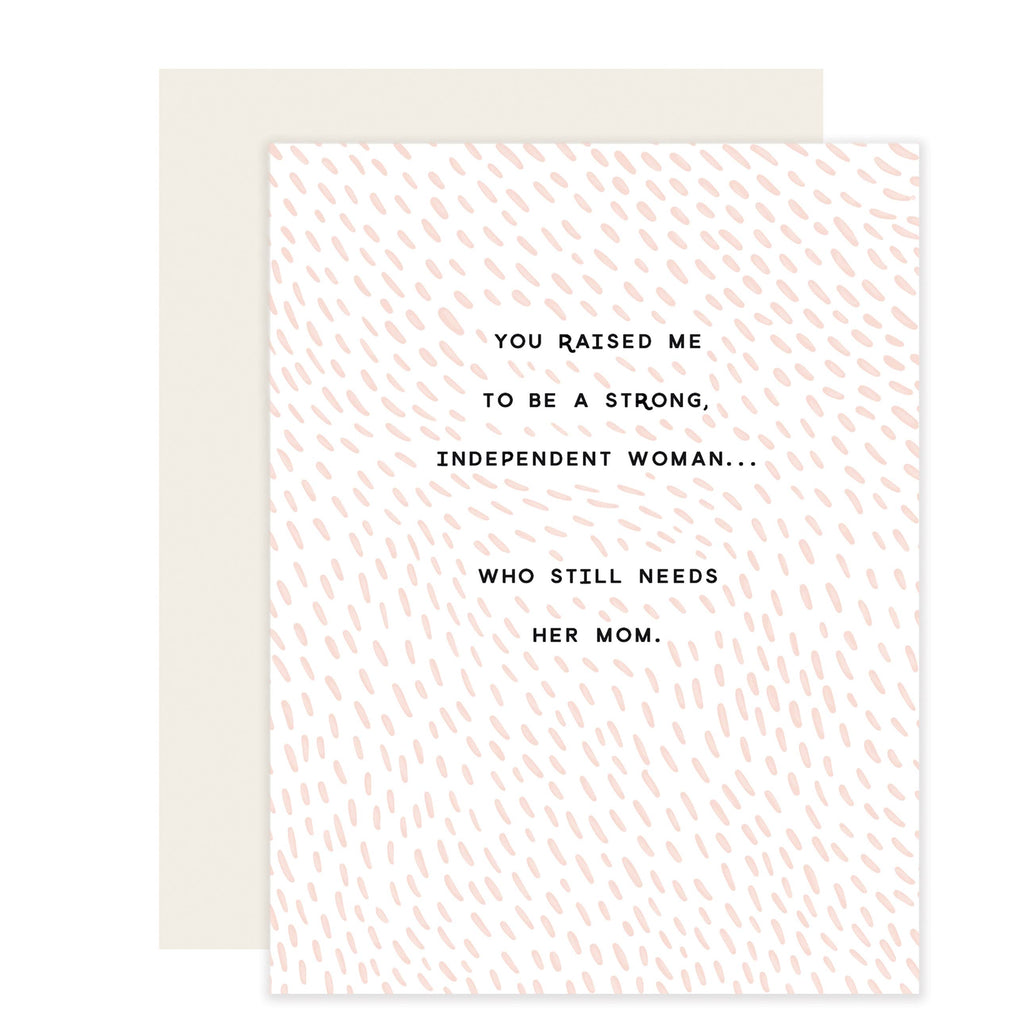 White card with black text saying, “You Raised Me To Be A Strong, Independent Woman…Who Still Needs Her Mom”. Images of peach colored specks scattered across card. An ivory envelope is included.