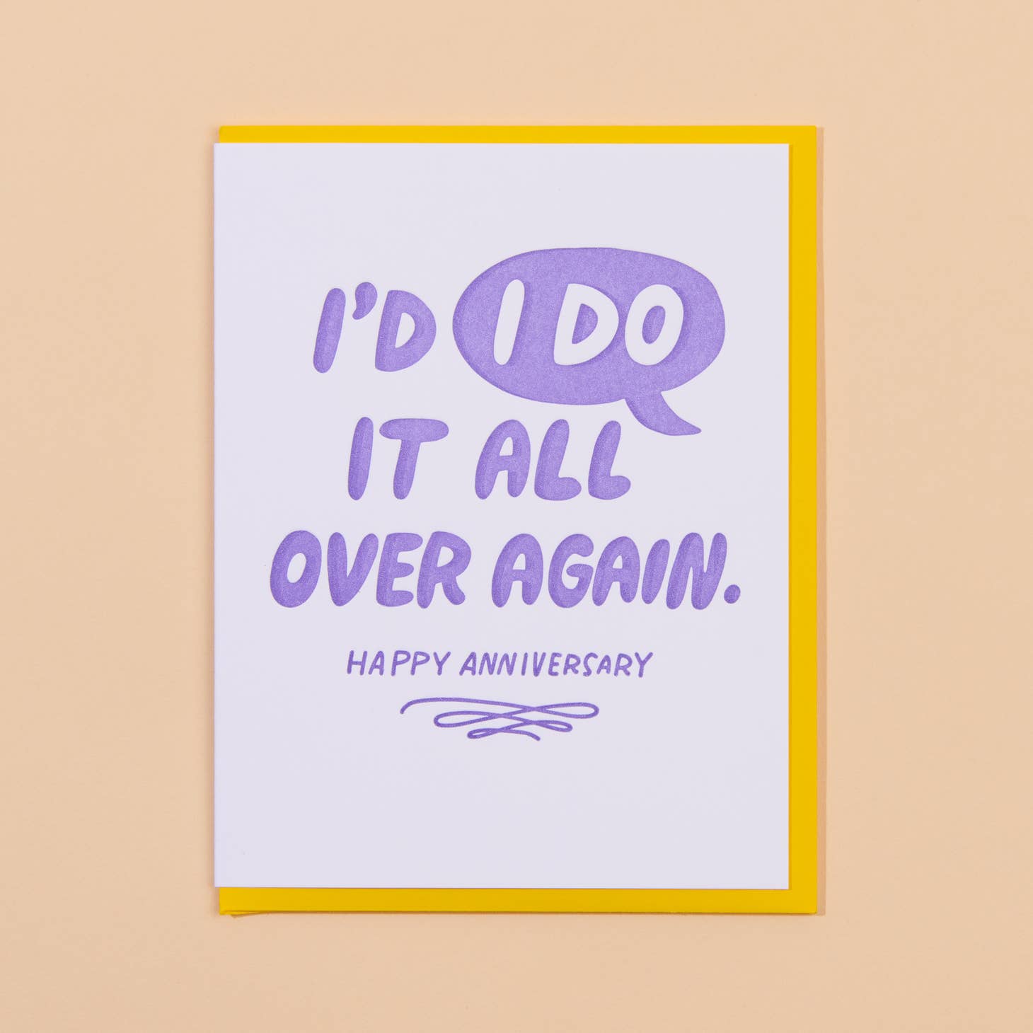 White card with lavender text that says “I’d I do it all over again” and “Happy anniversary” with a lavender swirly doodle underneath the text.  The “I Do” is in a quotation bubble. Yellow envelope is included      