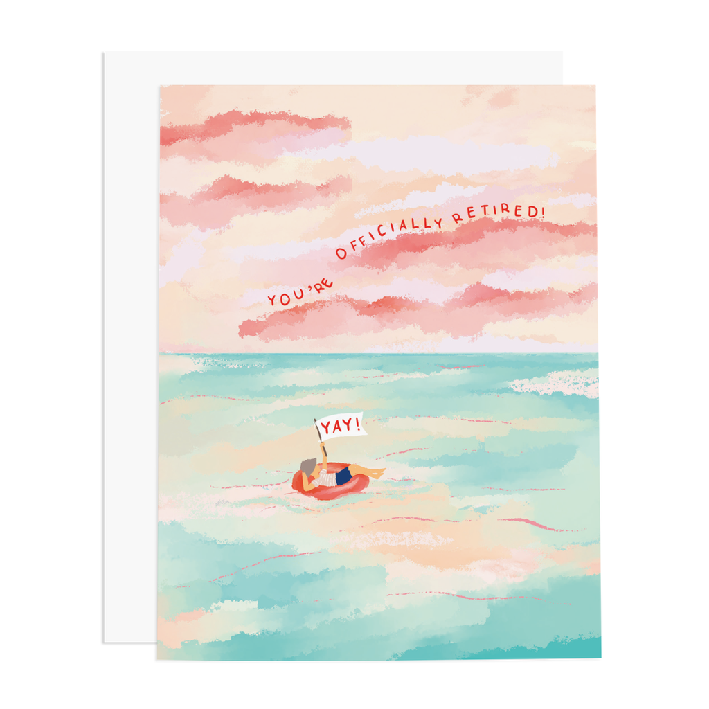 White card with images of a peaceful ocean scene with blue water and pink and red sky. Person floating on raft in water and red text saying, “You’re Officially Retired! Yay!” A white envelope is included.