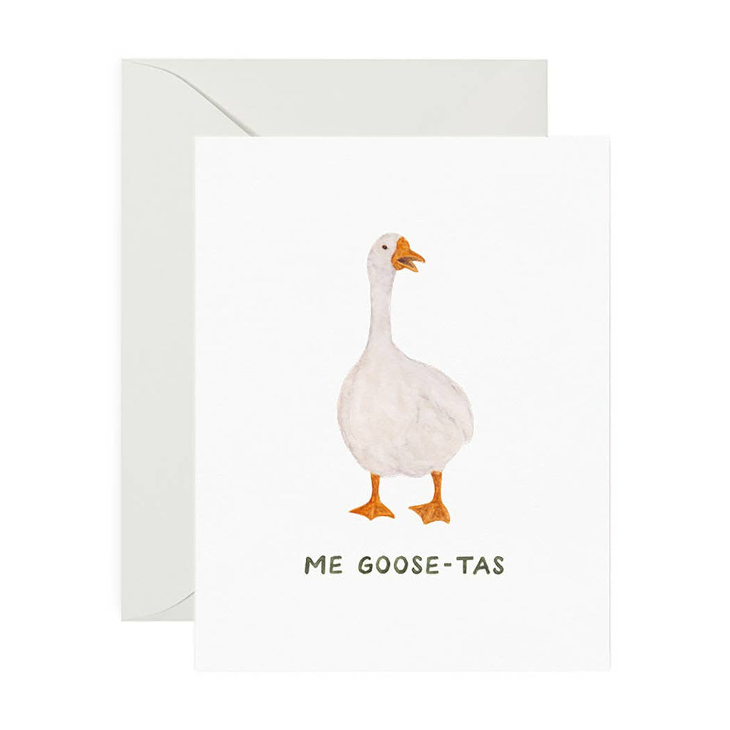 White card with green text saying, “Me Goose-Tas”. Image of a white goose in center. A gray envelope is included. 