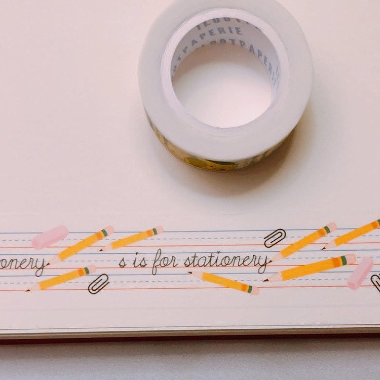 Decorative tape with notebook paper background with black text saying, "S is for Stationery". Images of yellow pencils, paperclips and pink erasers. 