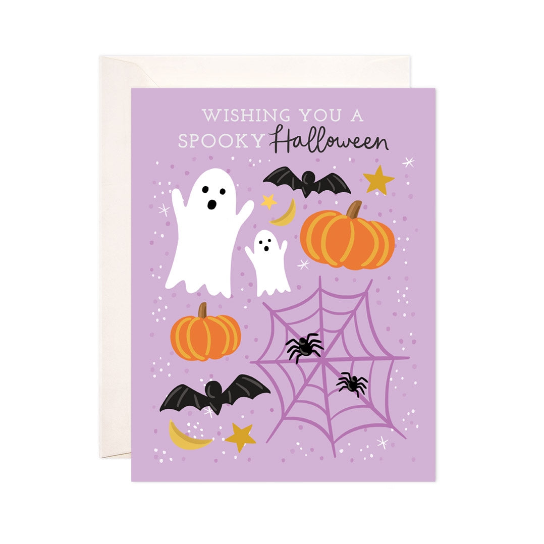 Purple card with white and black text saying, "Wishing You A Spooky Halloween". Images of white ghosts, black bat, spider web, spiders and pumpkin. An ivory envelope is included.