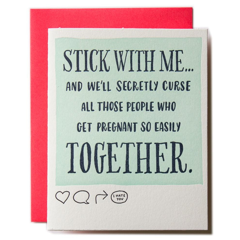 White card with sage green insert and black text saying, "Stick With Me...And We'll Secretly Curse All Those People Who Get Pregnant So Easily Together".  A red envelope is included.