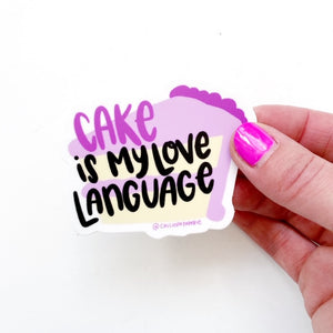 Image of a slice of cake with pale yellow cake and pink frosting with bright pink trim a bright pink text says, “Cake” and black text says, “is my love language”.
