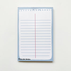 Image of notepad with image of white piece of memo notepad paper with blue lines and a red vertical line down the middle on a blue background. 