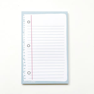 Image of page of notebook paper with blue lines and red margin vertical line and three holes with frayed edge on left on a blue background. 