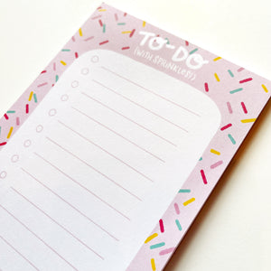 Image of notepad with pink border with multicolored sprinkles and white center with pink lines and checkboxes. White text says, "To-Do with (with sprinkles!).