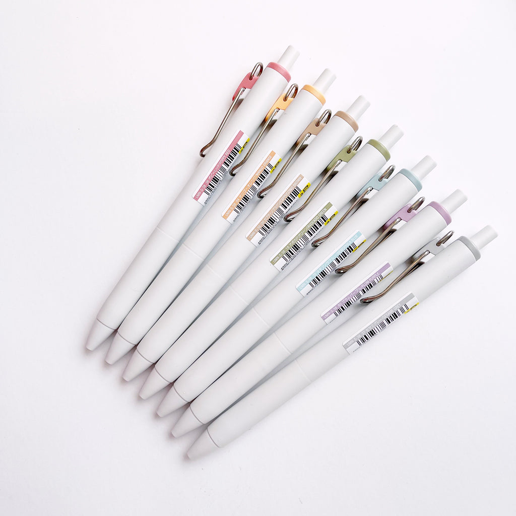 Assortment of 7 pens with white barrels and colorful clips that correspond to the ink color. Pens are in rainbow order.