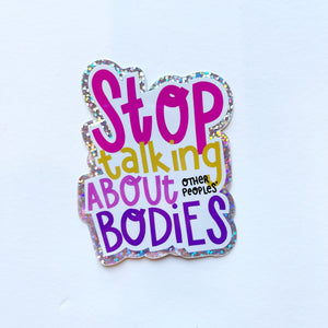 Image of sticker with white background and hot pink text says, "Stop", yellow text says, "Talking", pink text says, "about", black text says, "other peoples', purple text says "bodies" with holographic edging. 
