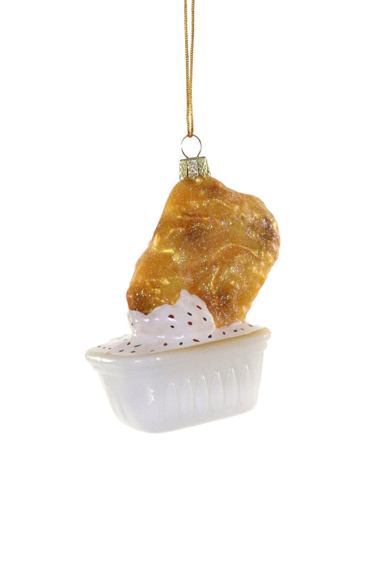 Image of golden chicken nugget with ranch dressing and white cup. 