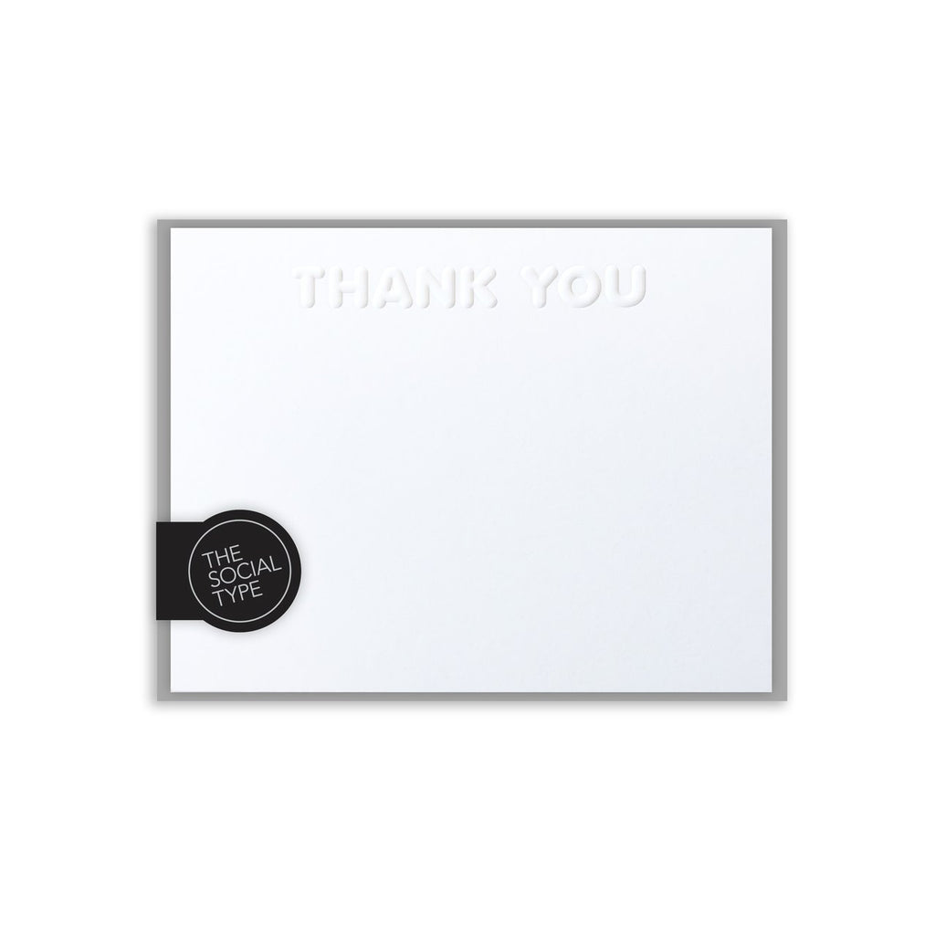 Image of white notecard with embossed "thank you" with gray envelopes. 