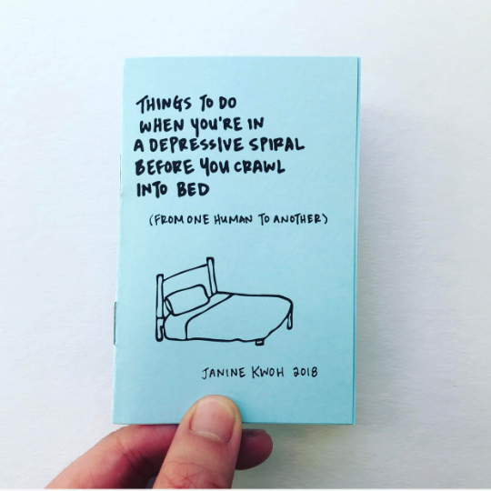 Image of two pages of zine with blue background and black text says, “Things to do when you’re in a depressive spiral before you call into bed”, “From one human to another” which a drawing of a bed. 