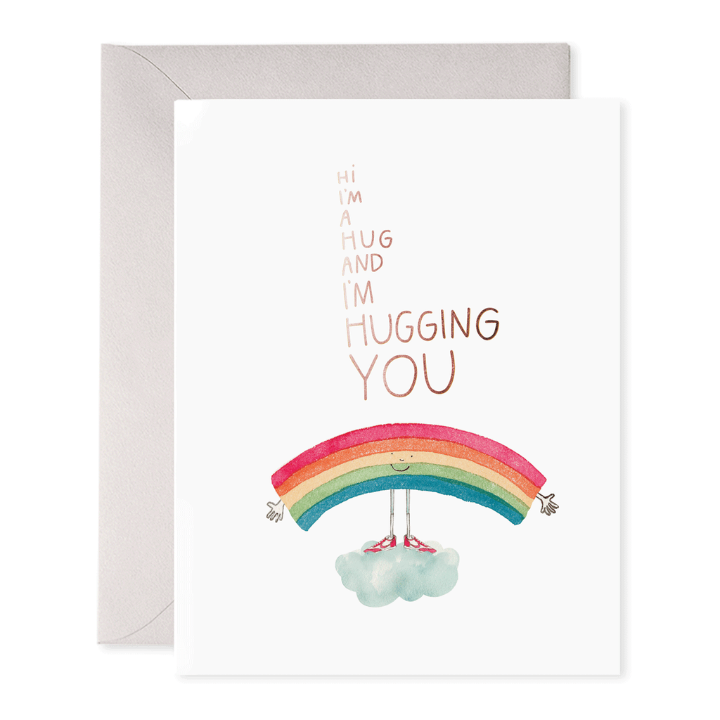 White card with brown text saying, “Hi I’m A Hug And I’m Hugging You”. Image of a rainbow standing on a cloud with outstretched arms and a smile. A purple envelope is included.