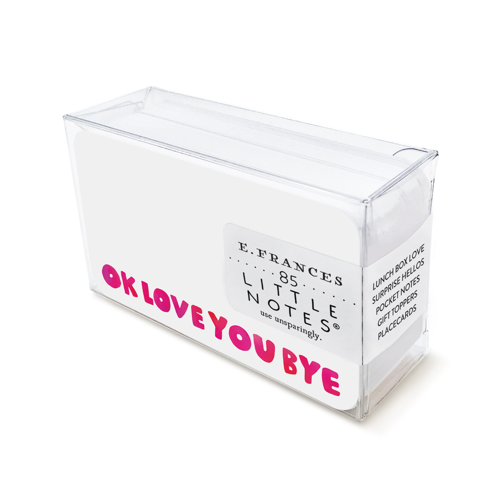 Image of a box of little notes. Little note has white background with red and pink text at the bottom edge of card says, “OK love you bye”. 