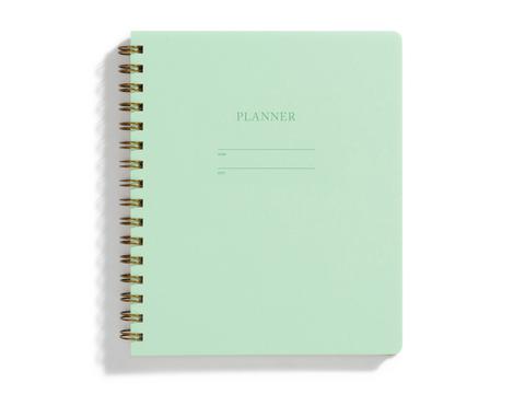 Image of mint cover with letter pressed text says, “Planner”. “Name” and “Date” with lines for writing. Coiled binding on left side.
