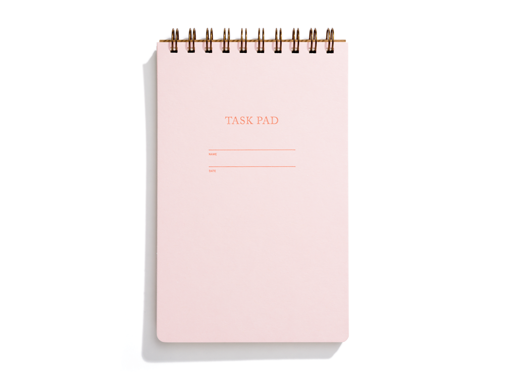 Image of pink cover with letter pressed text says, “Task pad”. “Name” and “Date” with lines for writing. Coiled binding on top.