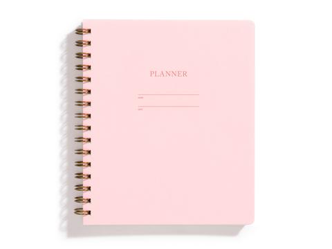 Image of pink cover with letter pressed text says, “Planner”. “Name” and “Date” with lines for writing. Coiled binding on left side.