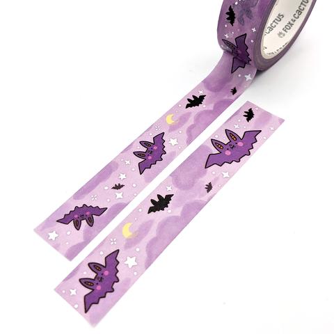 Decorative tape with purple background and images of purple and black bats with white stars and yellow moons.