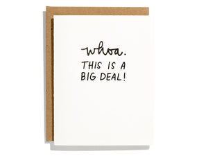 White card with black text saying, “Whoa. This Is A Big Deal!” A brown envelope is included.