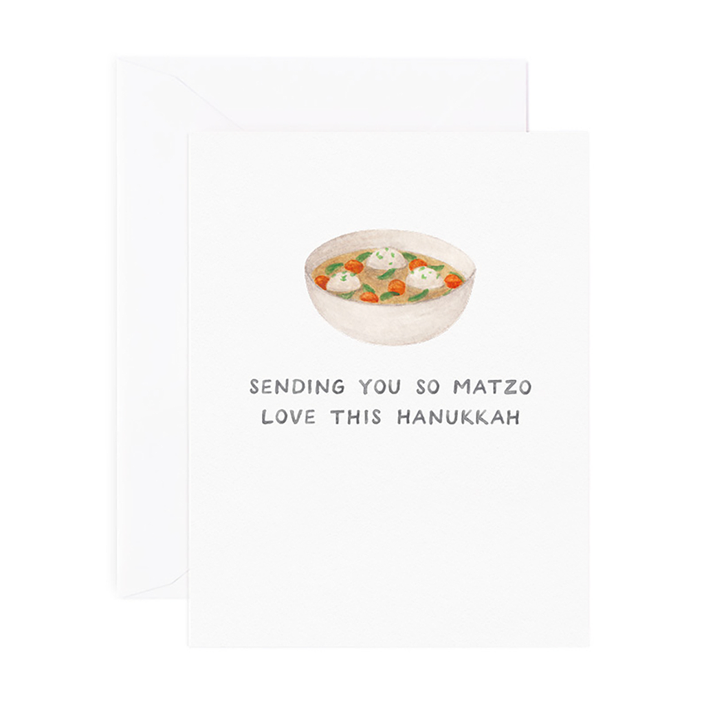 White card with black text saying, “Sending You So Matzo Love this Hanukkah”. Image of bowl of matzo ball soup in center. A white envelope is included.