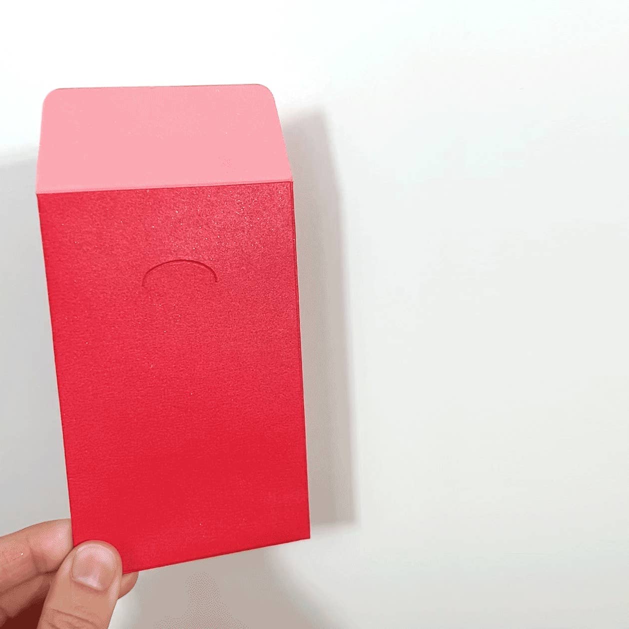 Red background with pink accent on flap closure. 