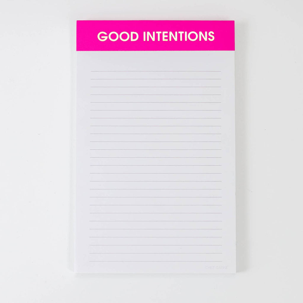 Image of a notepad with white lined paper a hot pink binding with gold foil text says, “Good Intentions”. 