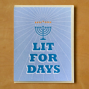 Blue card with blue block letter text saying, "Lit For Days".  Image of a blue menorah with lit candles.  A tan envelope is included.