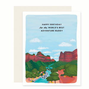 White card with image of scenic valley with rivers, green trees, red rock cliffs, blue sky and white clouds. Black text saying, “Happy Birthday to the World’s Best Adventure Buddy”. An ivory envelope is included.